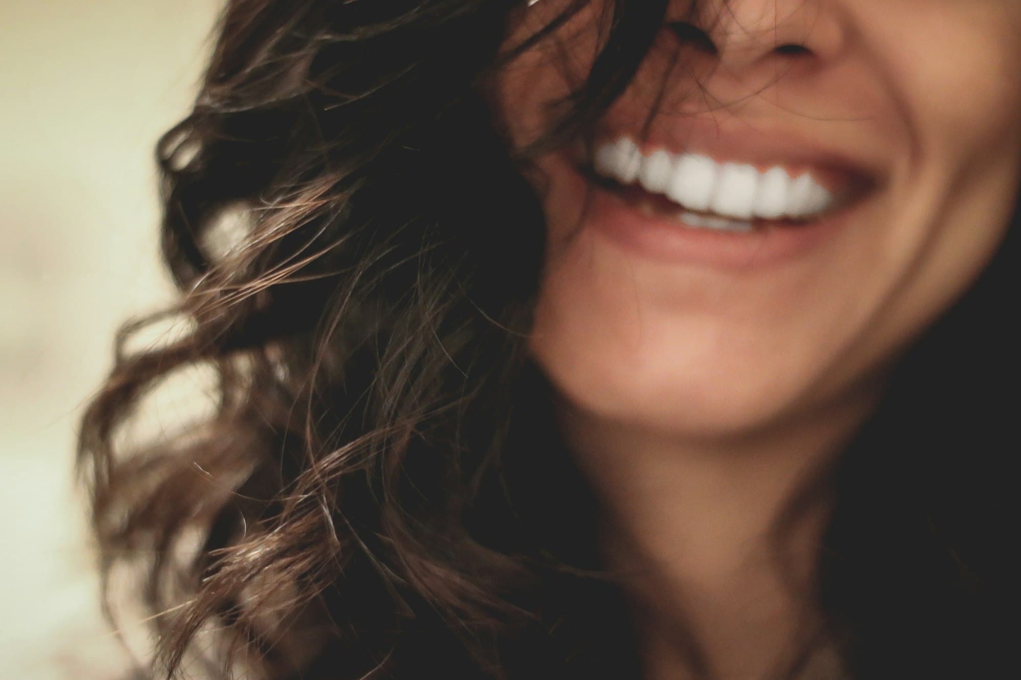 Mulher sorrindo, em foto de perto