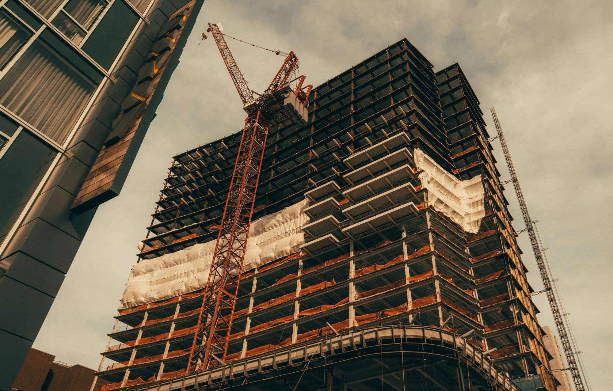 Prédio em construção com estrutura aparente e guindaste